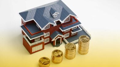 rmb-coins-stacked-in-front-of-the-housing-model-house-prices-house-buying-real-estate-mortgage-concept